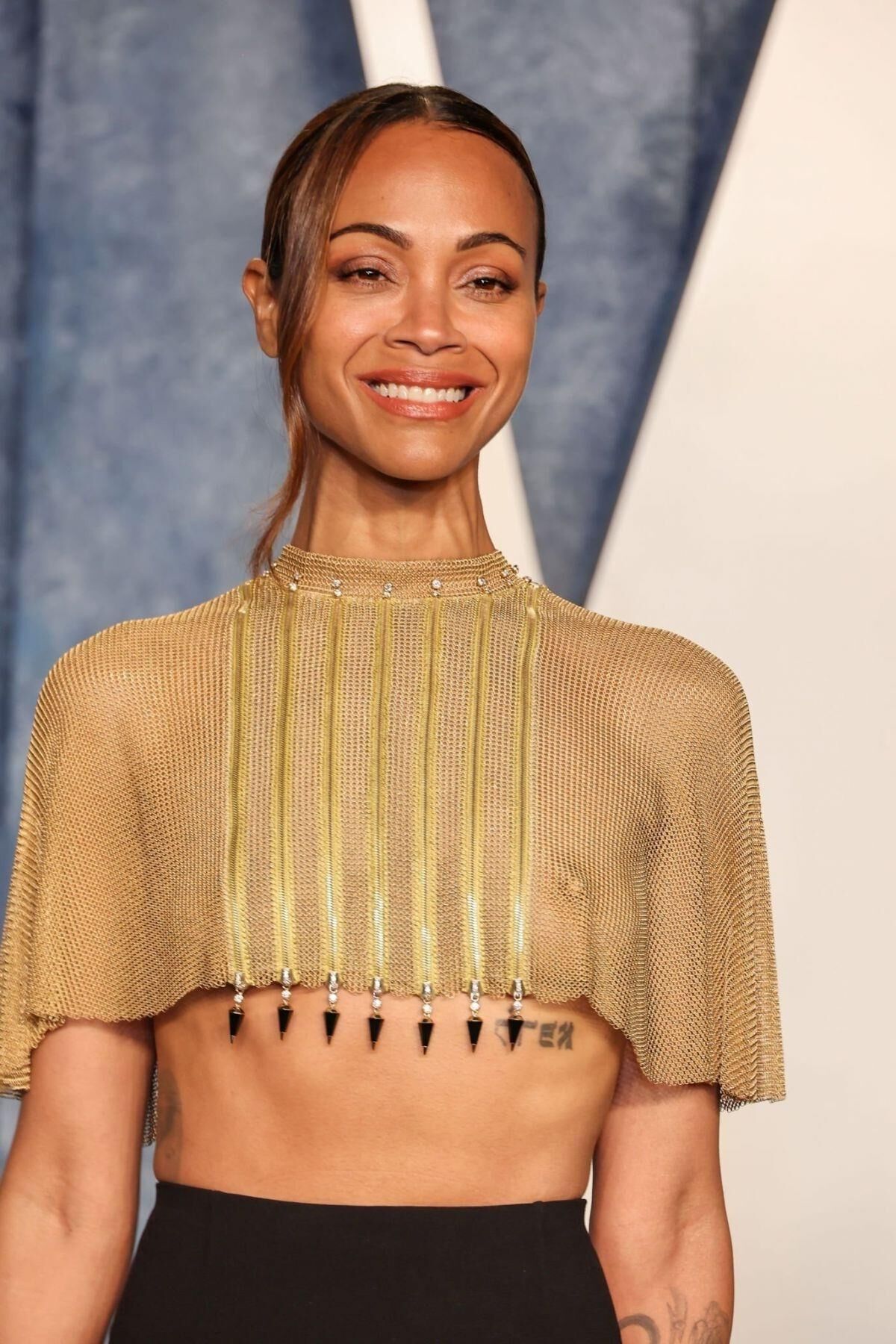 Les seins de Zoe Saldana drapés d'or