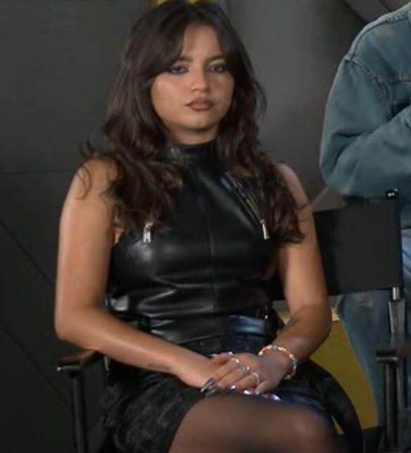 Isabela Merced touching her pantyhose legs in interview