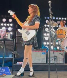 Jenny Lewis in fishnets, frilly white socks, and mary jane heels